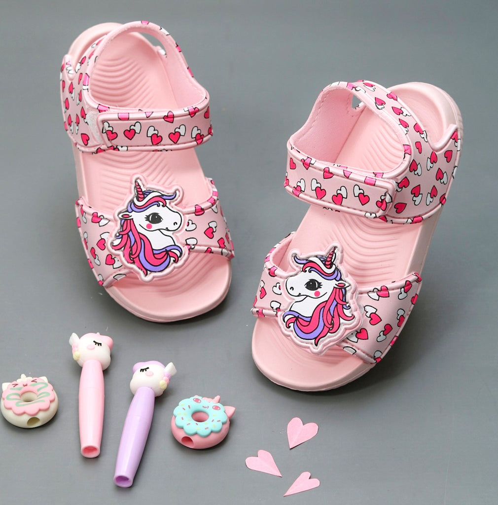 Child's unicorn sandals with heart patterns and magical unicorn decoration on pink straps.