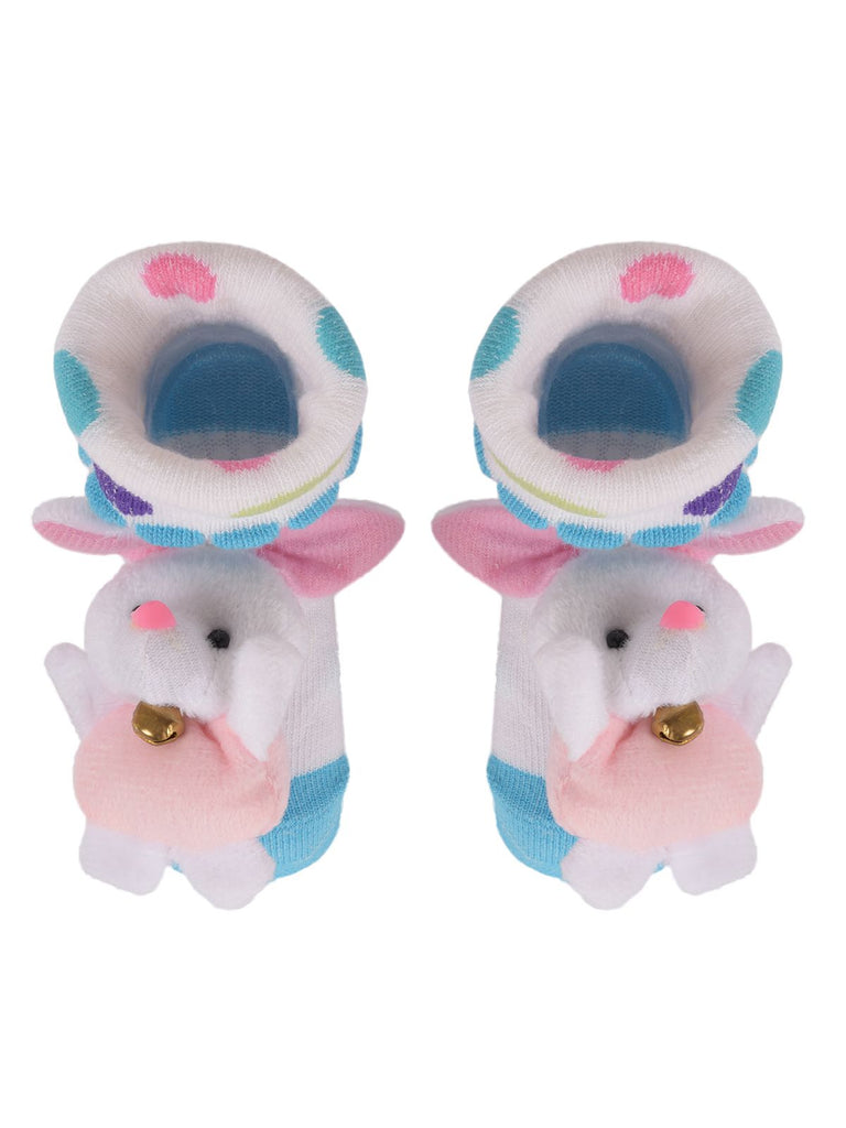 Top view of infant socks with plush bunny stuffed toy and colorful patterns.