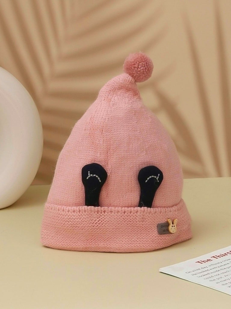 Soft pink winter beanie with eye applique and pom-pom, designed for girls 1-2 years old.
