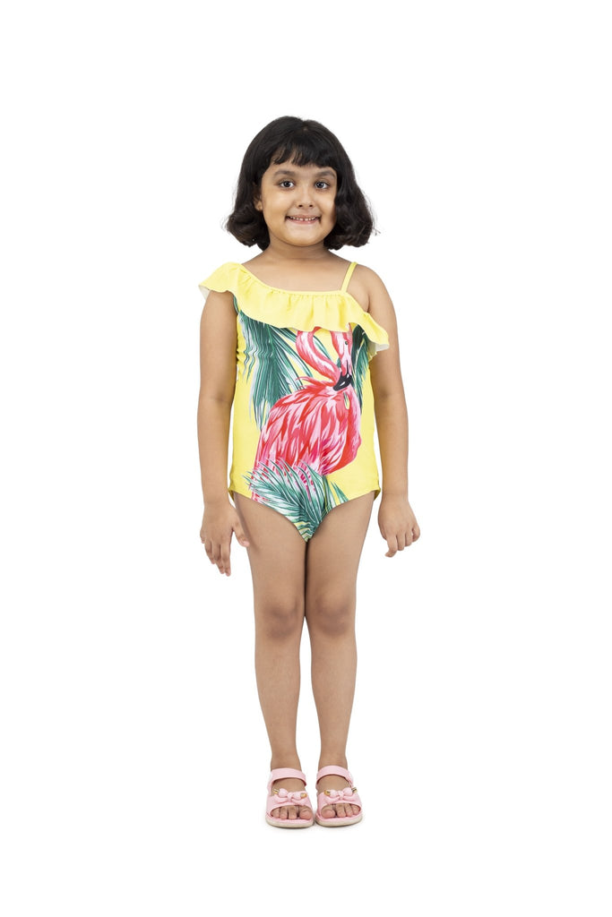 Front view of a happy girl wearing Yellow Bee's flamingo print swimsuit with ruffle sleeves.