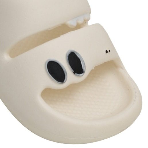  Close-up of the white dino sandal's face with black scale details, showing a friendly dino character.