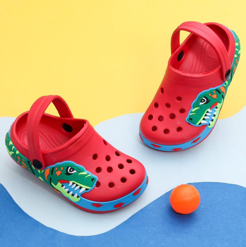 Kids' red clogs with colorful dinosaur print and blue trim, ready for adventurous play