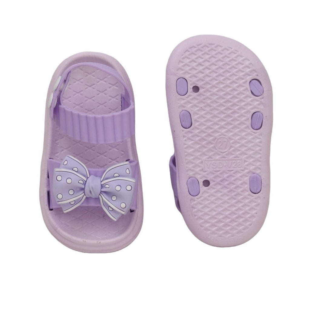 The underside view of purple bow detail sandals displaying the non-slip pattern for safety