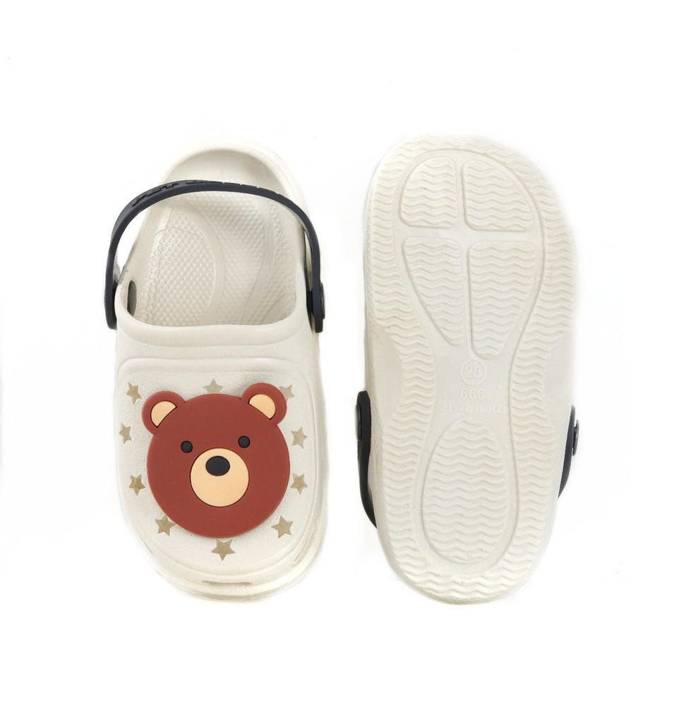 Bottom view of a kid's beige clog showing the anti-slip tread pattern for safety.