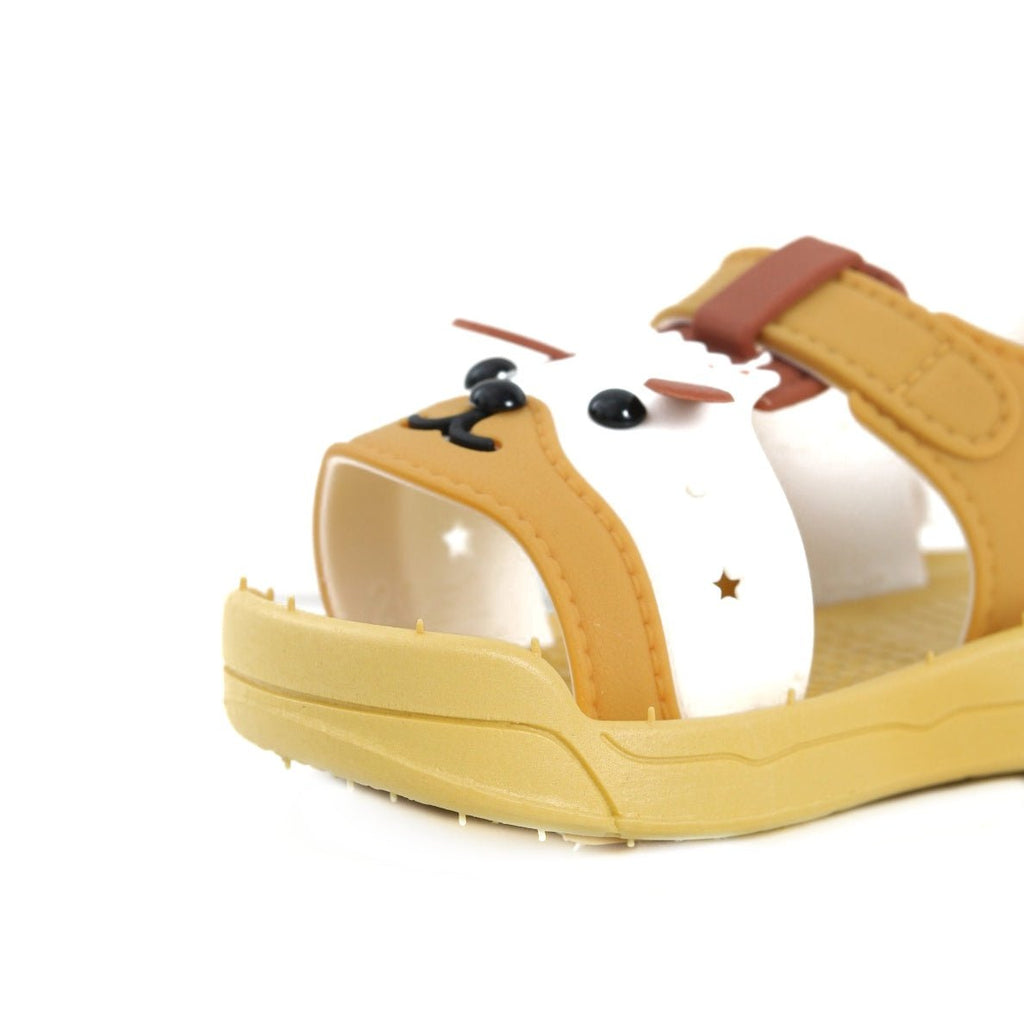 Close-up side view of yellow puppy sandals emphasizing the facial details and soft edges.