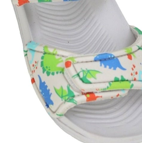 Zoomed-in view of a kid's grey sandal with straps adorned with various dinosaurs, ready for adventure.