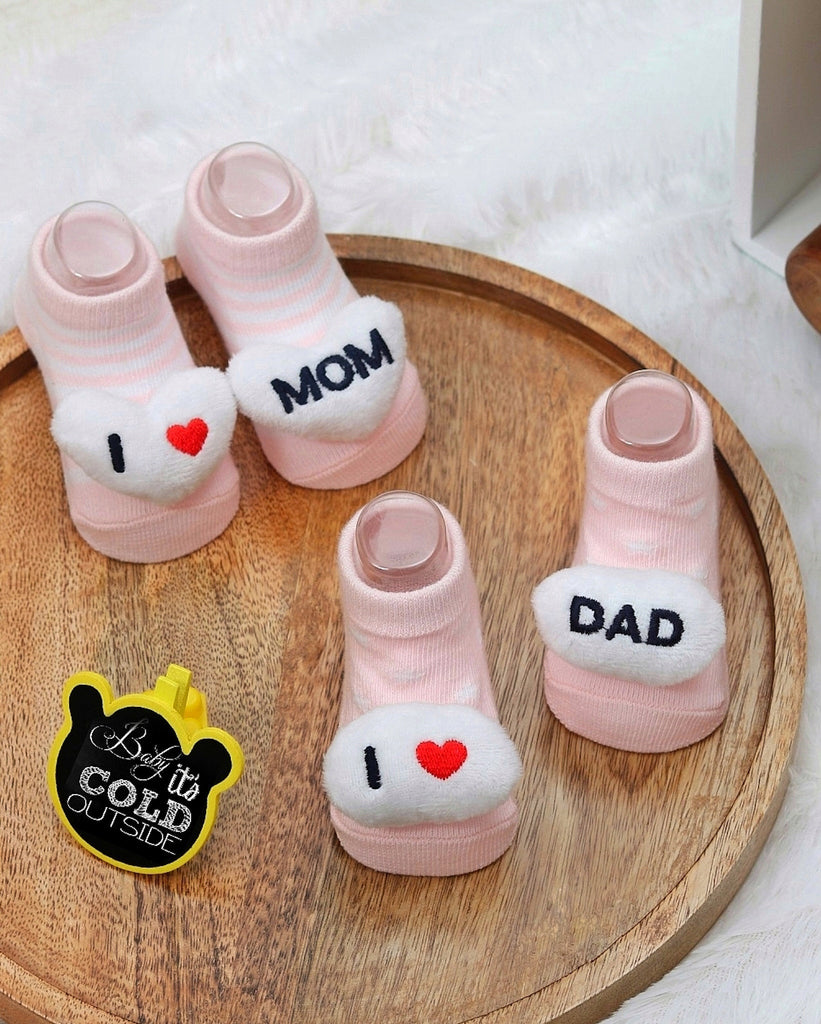 Pink baby socks with "I love MOM" and "I love DAD" messages, cozy 3D details, and anti-slip soles by Yellow Bee.