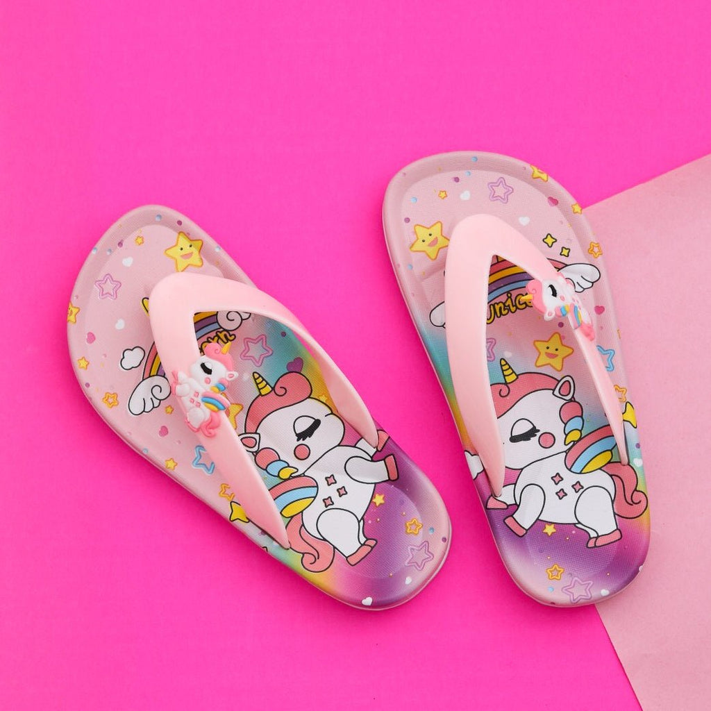 Pair of kids' pink unicorn thong flip-flops with a colorful print on a vibrant pink background.