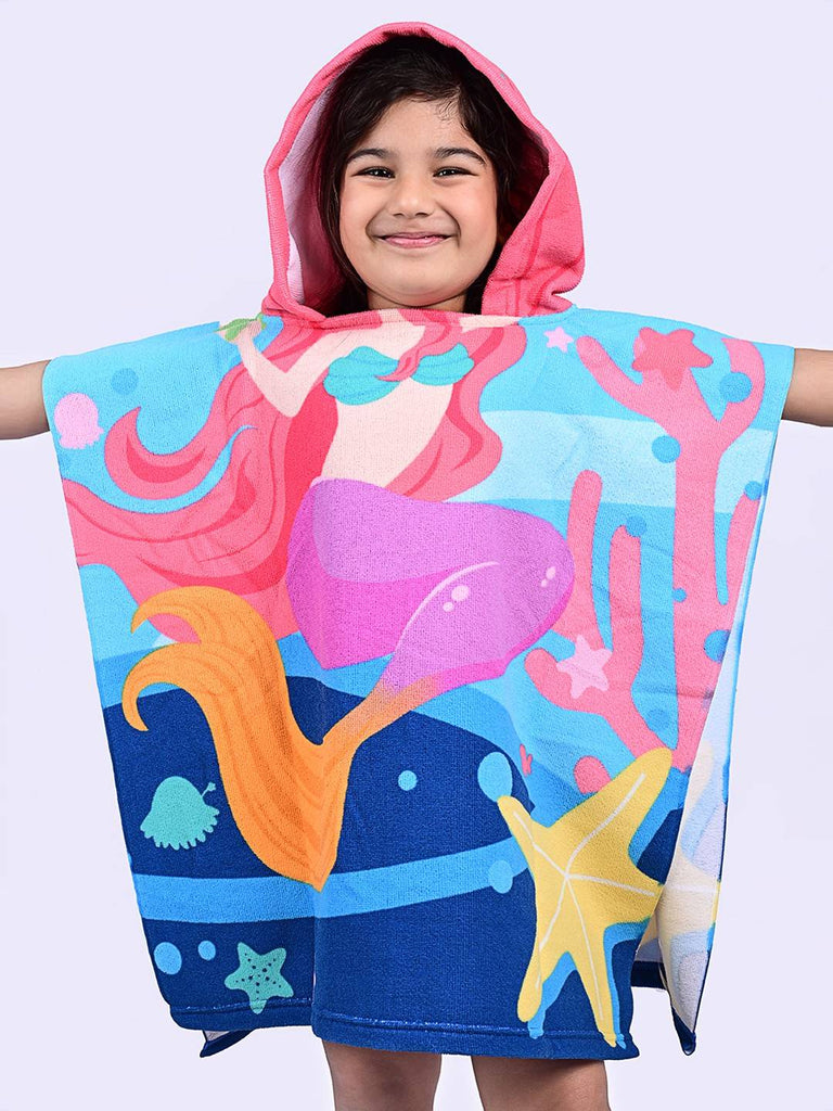 Happy girl with arms spread wearing Yellow Bee's mermaid hooded poncho towel
