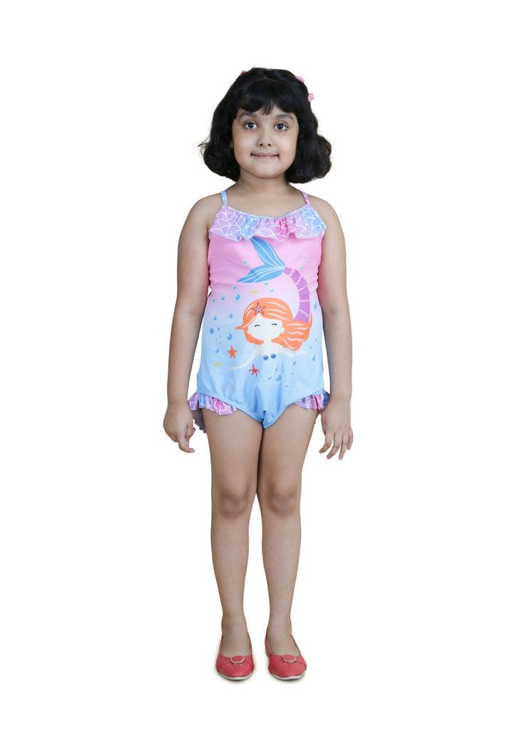 Front view of young girl smiling in her mermaid-theme swimsuit with ruffles