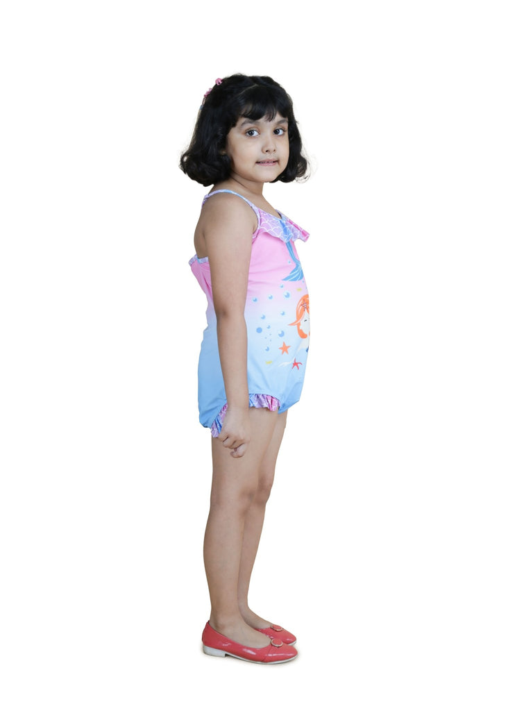 Side view of girl wearing a mermaid print one-piece swimsuit with ruffles by Yellow Bee.