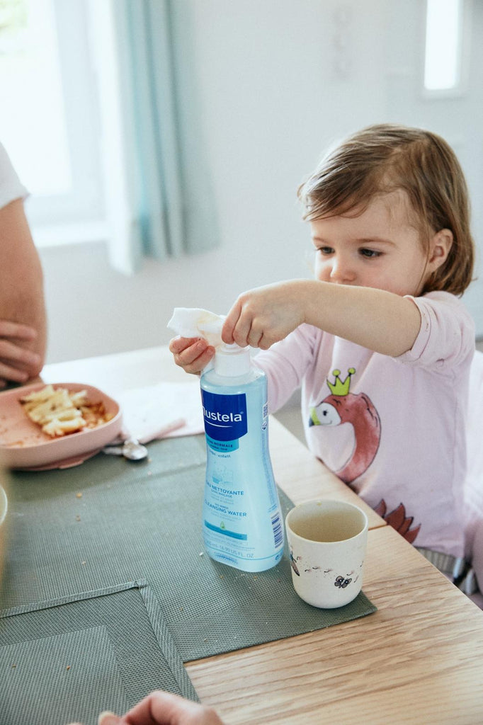 Young Child Using Mustela Baby Cleansing Water During Mealtime