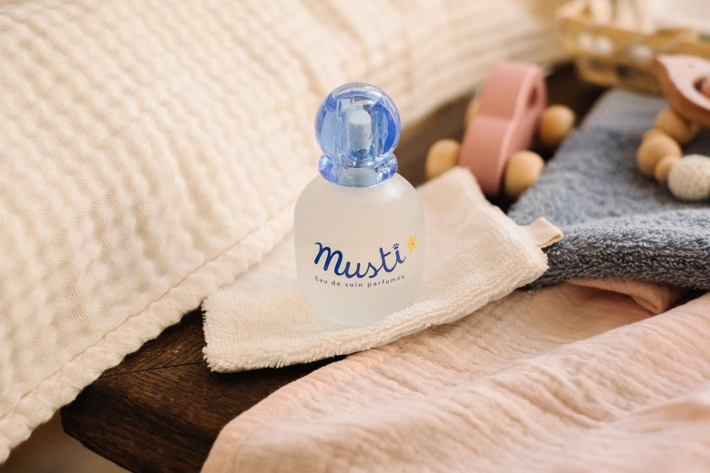 Mustela Musti Baby Scent placed thoughtfully on a wooden surface, surrounded by soft baby blankets and toys, ready for a gentle spritz