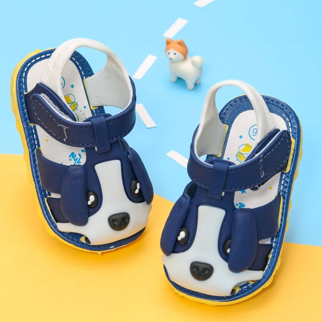 Two blue puppy applique kids sandals on a playful background with toy figure.