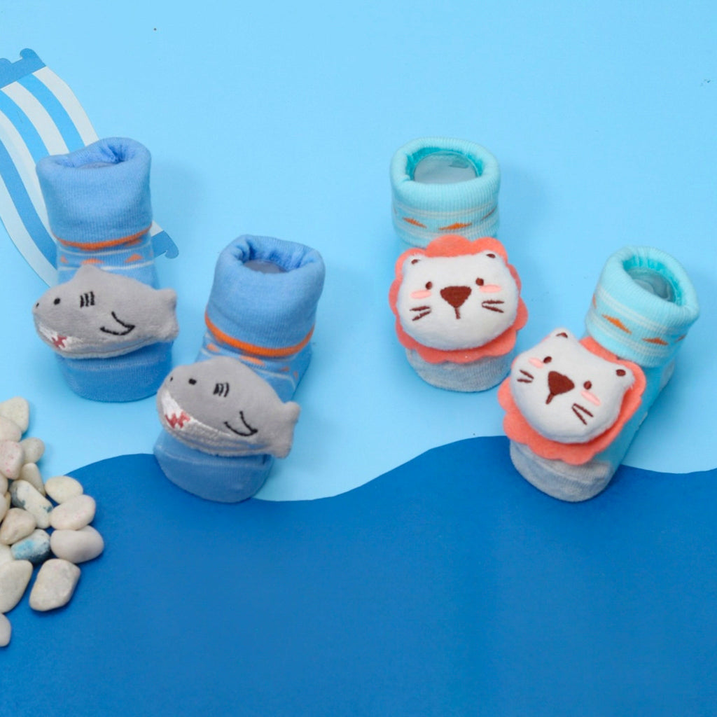Colorful set of baby boy socks with playful lion and shark characters.