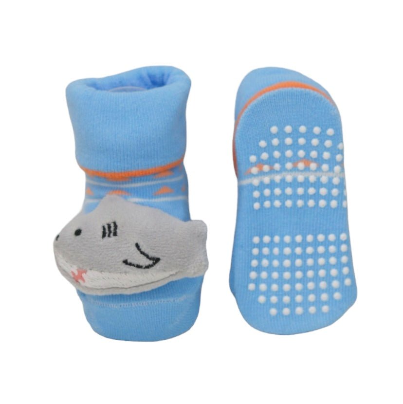 Close-up of baby boy's blue socks with a smiling shark applique.