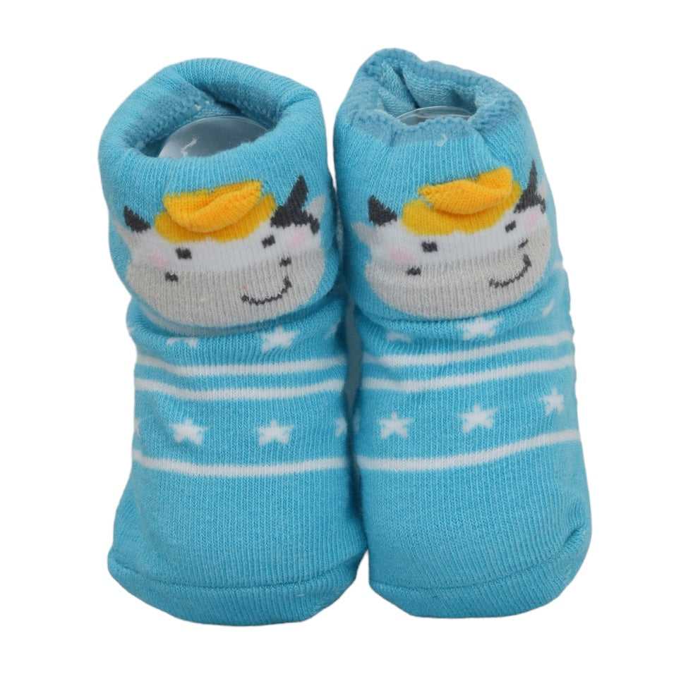 Blue baby socks with unicorn design and stars on wooden floor