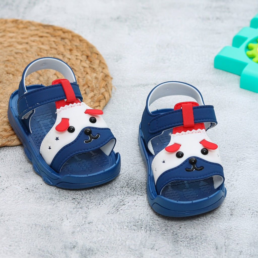 Blue Puppy Sandals for toddlers with a red strap detail and playful puppy face, on a textured background.