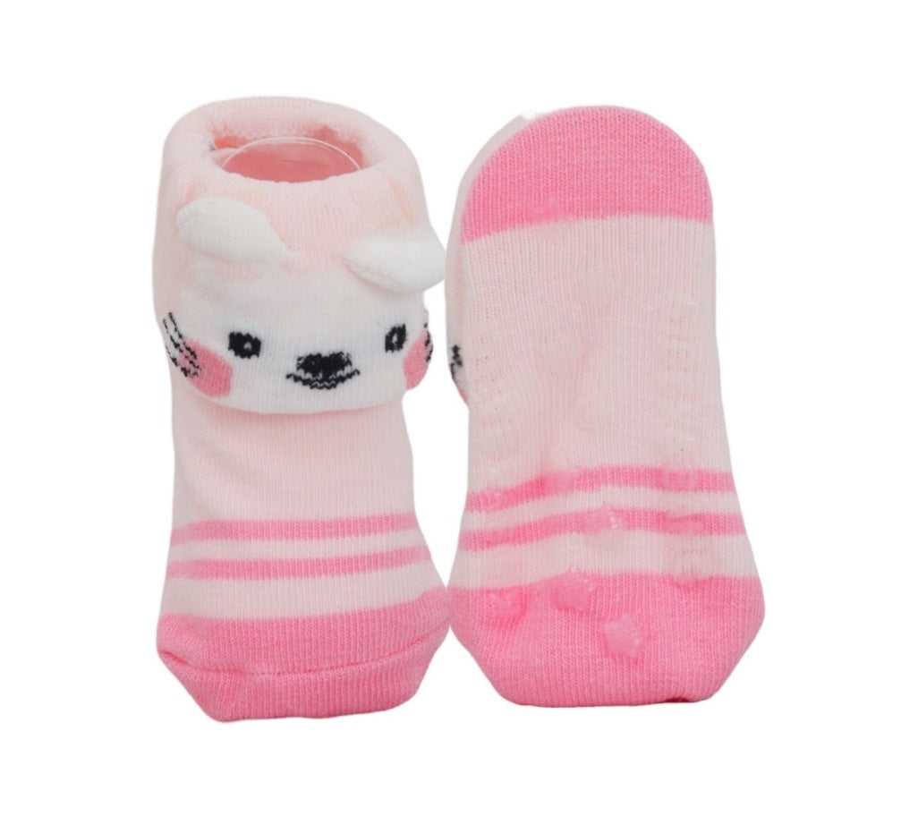 Bottom view of pink baby girl socks with white stripes showing the non-slip design.