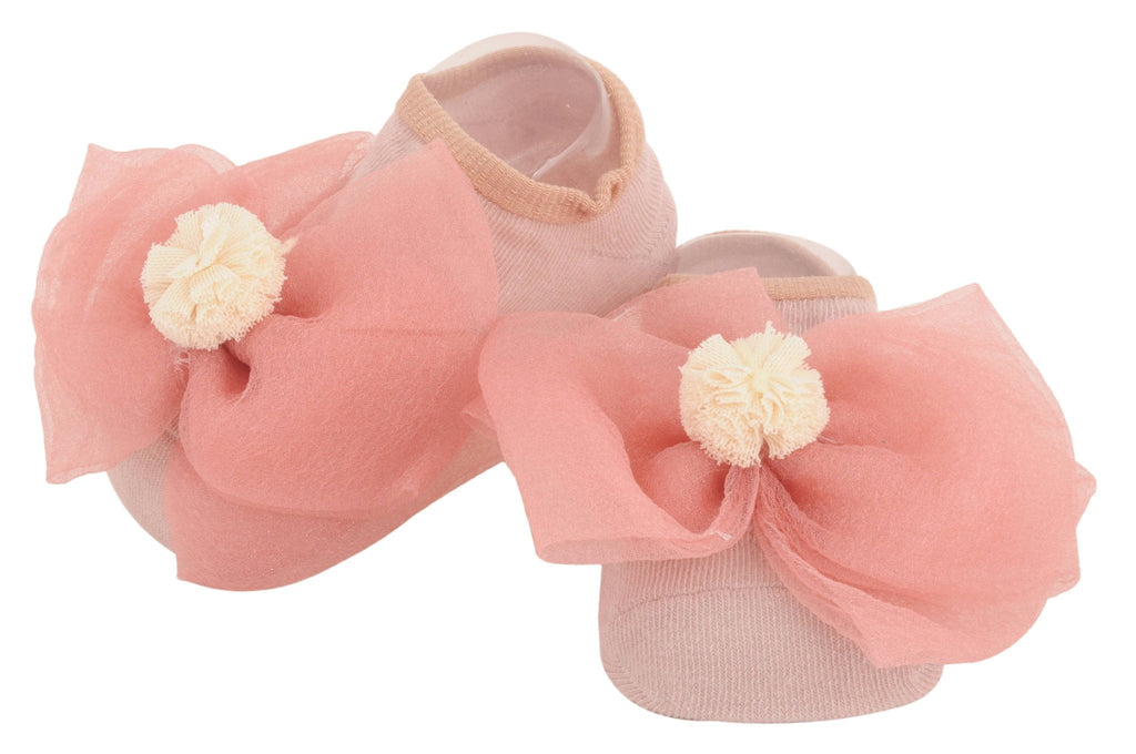 Side perspective of children's peach socks featuring a soft bow and flower decoration