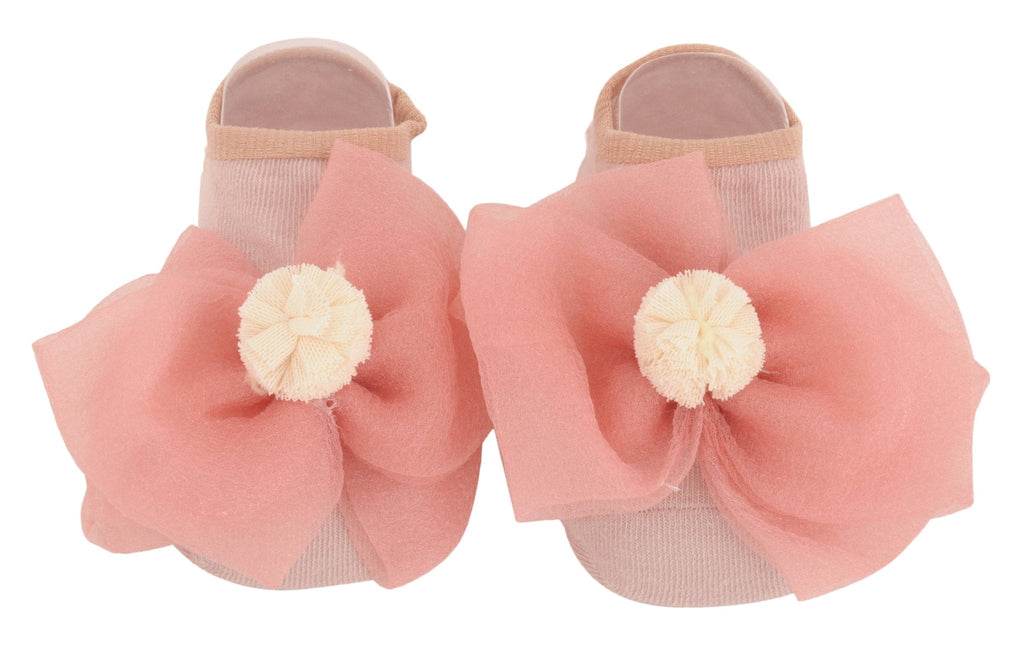 Pair of peach-colored socks with a large decorative bow and flower for children - top view.