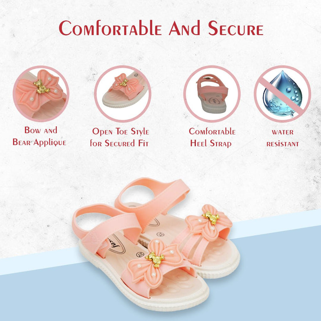 Infographics top view of peach sandals highlighting the bow and bear appliqué and open-toe design
