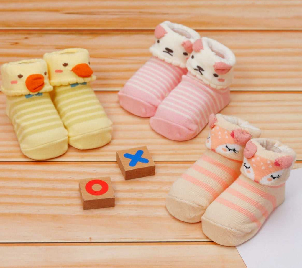 Assorted animal-themed anti-skid socks for baby girls displayed with playful blocks and tic-tac-toe.
