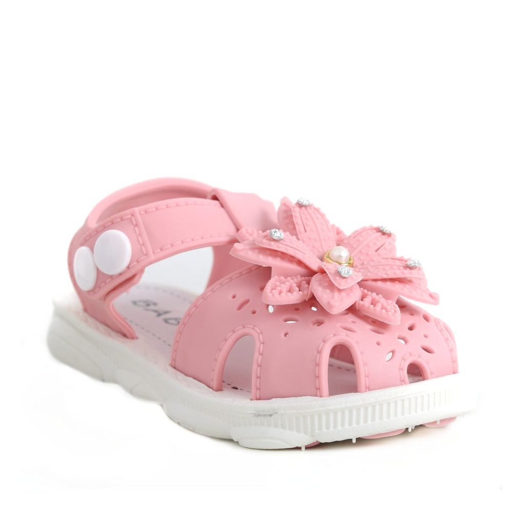 Front view of a toddler's pink sandal with floral decoration and a white sole.