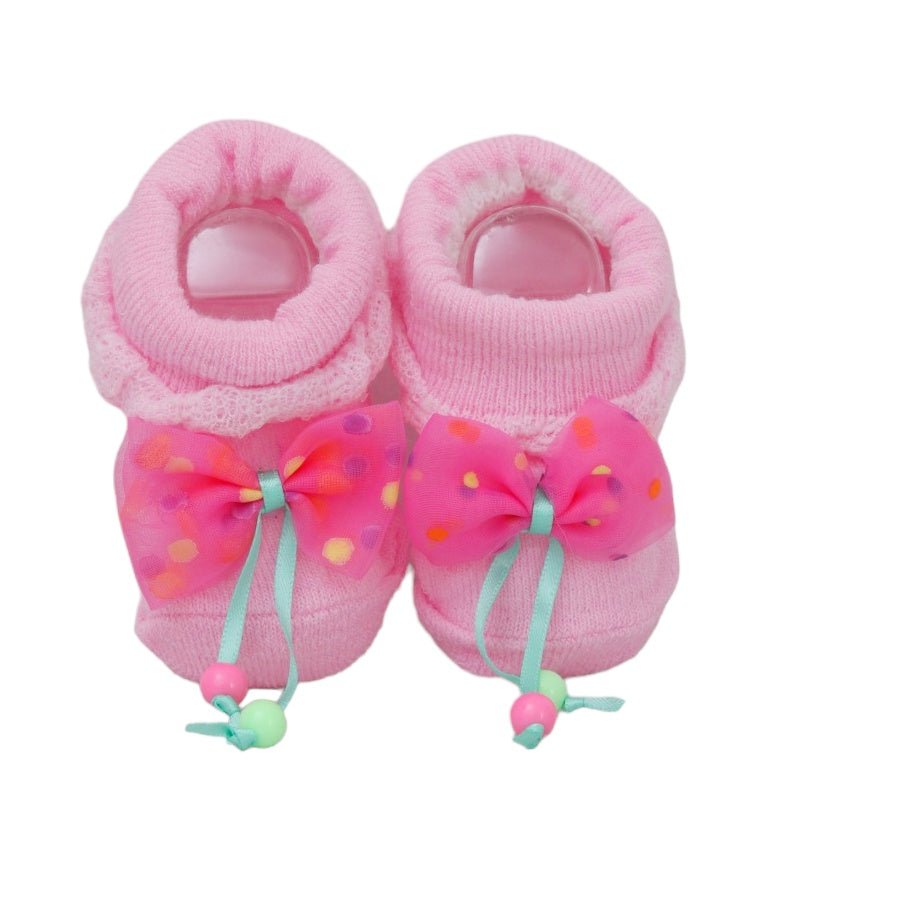 Close-up of baby girl socks with pink polka-dot bows and bead accents.