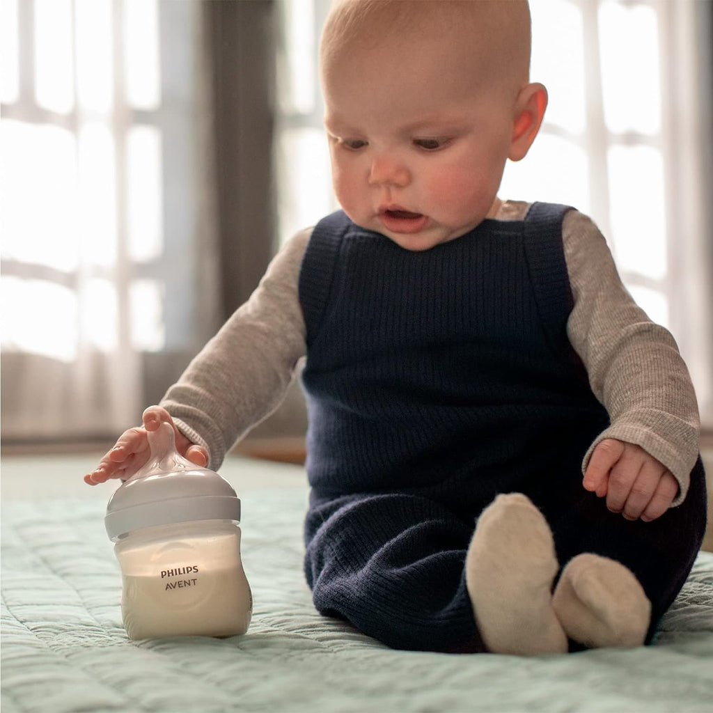 Baby confidently holding Philips Avent Natural Response Baby Bottle