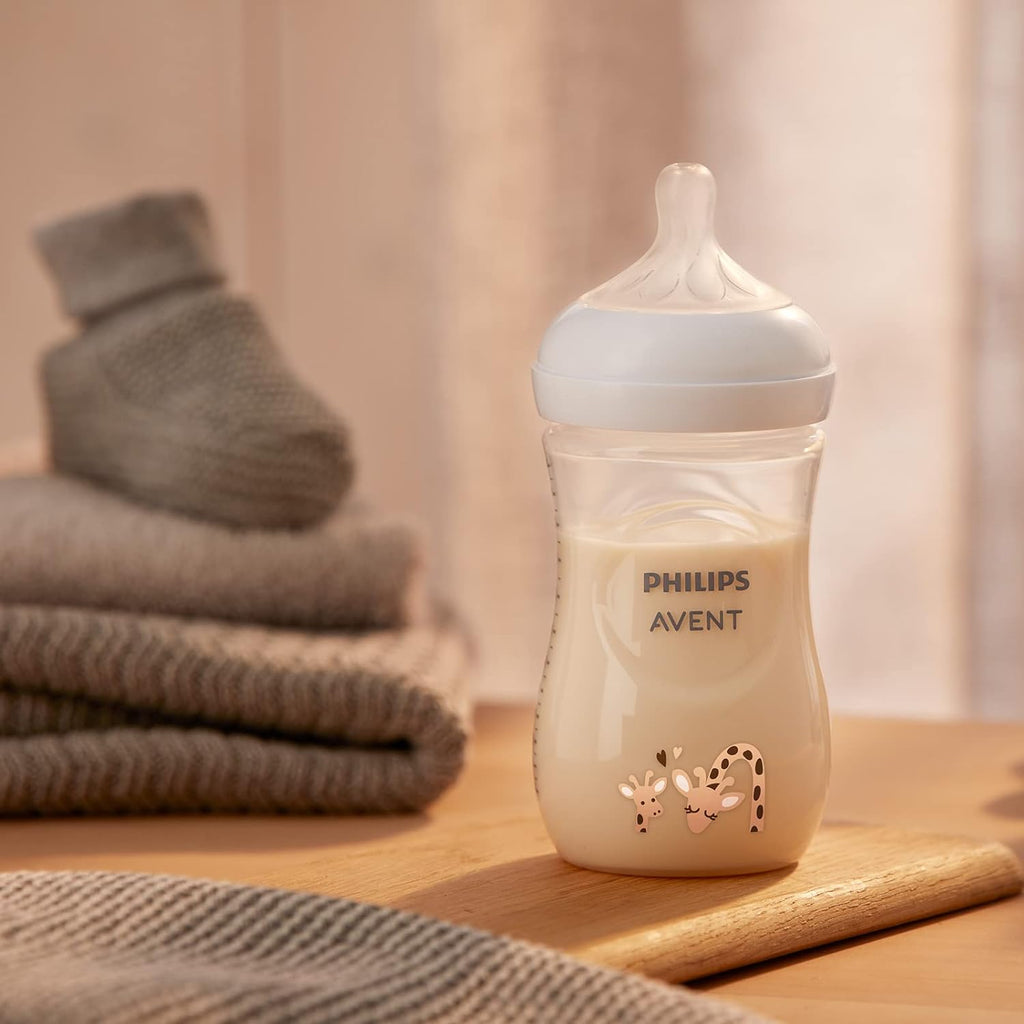 Philips Avent SCY903/66 bottle filled with milk, accompanied by cozy knitted fabrics.