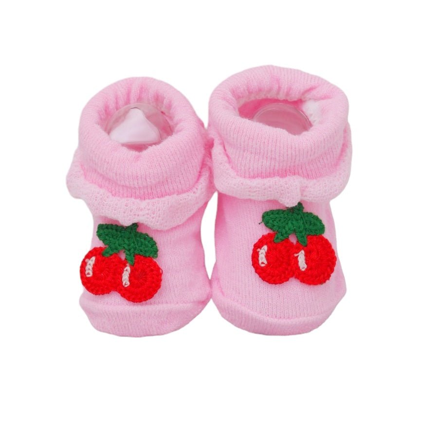 Vibrant cherry appliqué on pink baby socks, front view on a white backdrop.