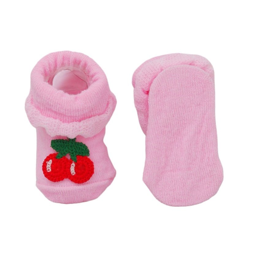 Pink baby socks with cherry decoration, sole view showing the texture for grip.