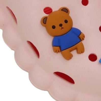 Close-up of the toy bear detail on the white toddler clogs, illustrating the playful theme