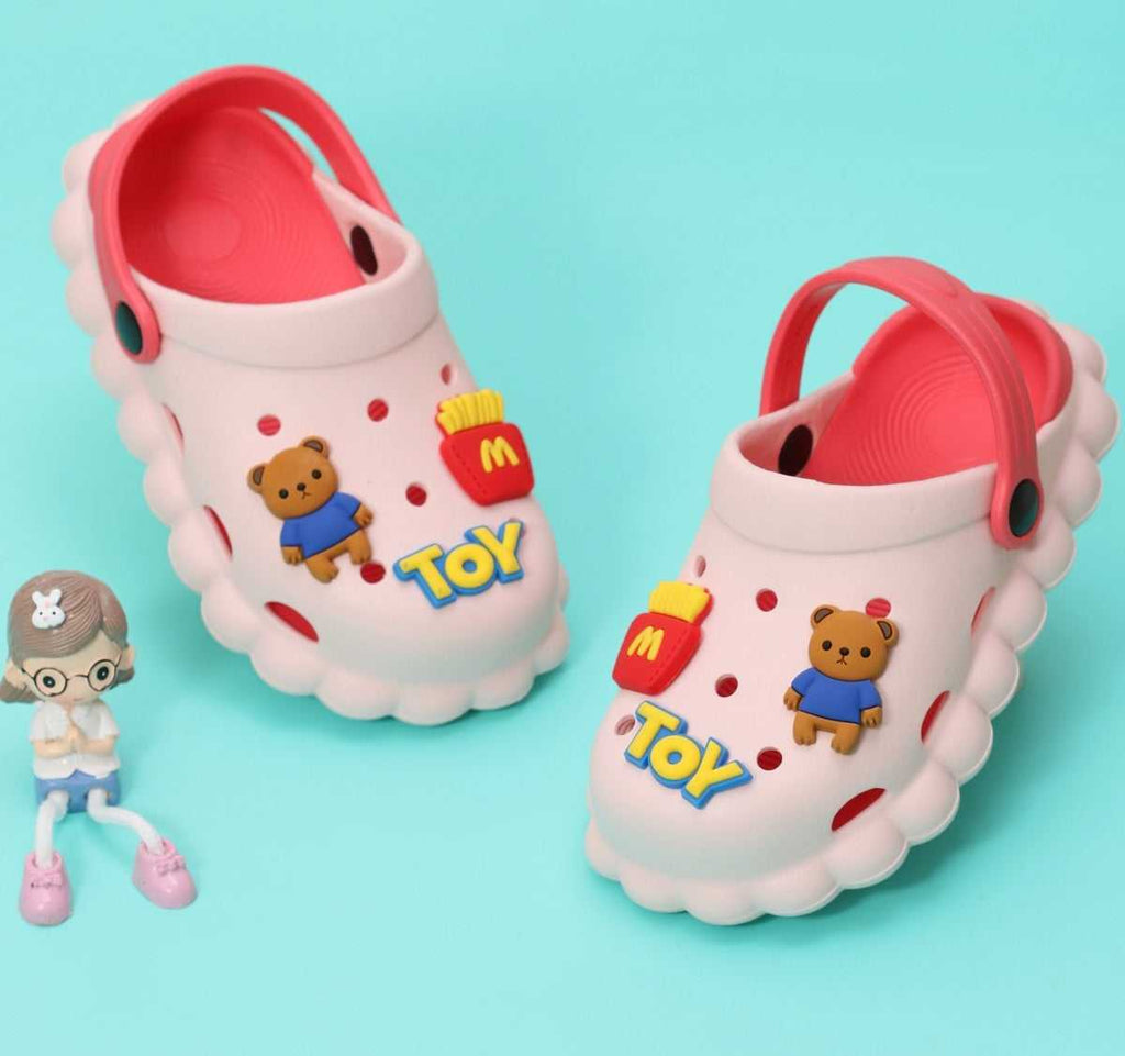Cheerful white toddler clogs with red accents and playful toy bear and fast food motifs on a teal background.