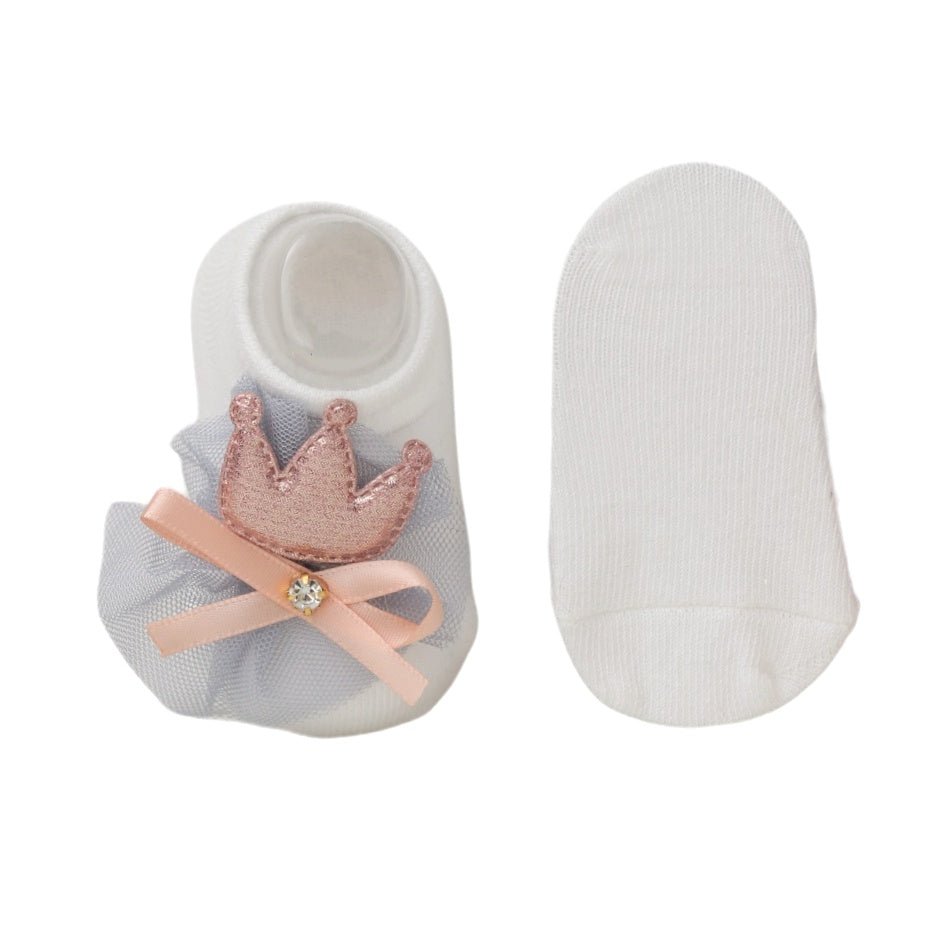 Single white princess crown baby sock alongside a plain white sock