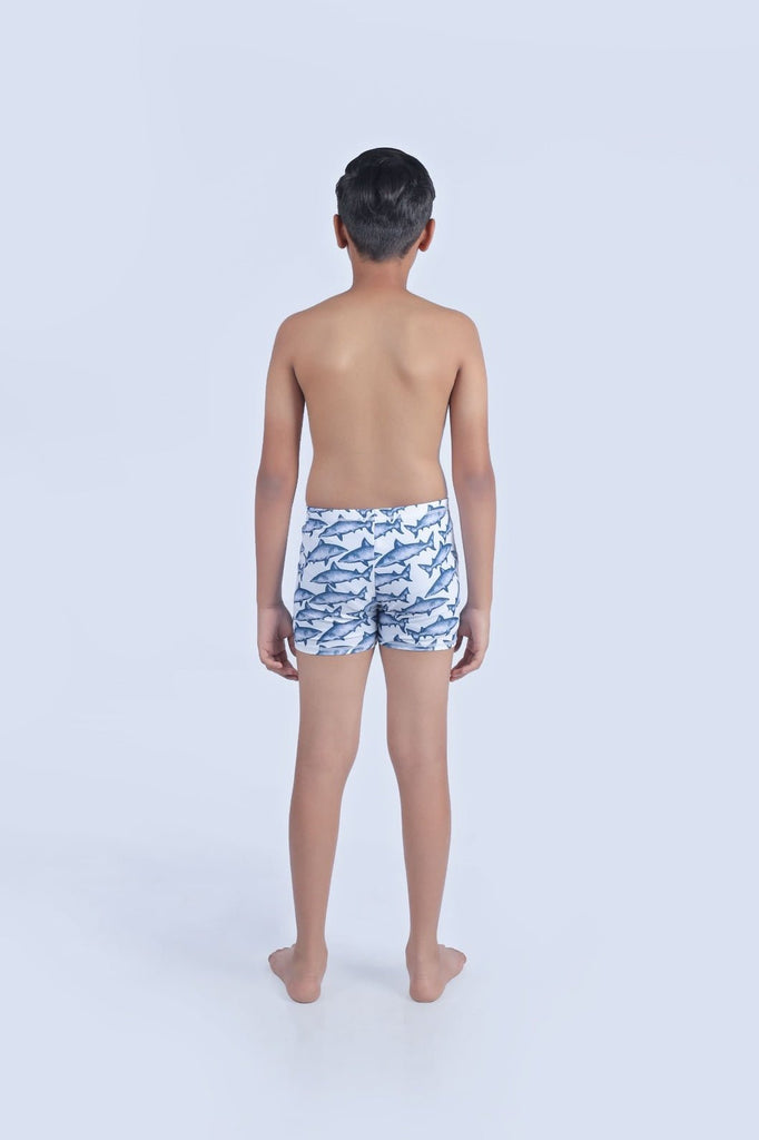 Back view of a child in Yellow Bee swim shorts with an all-over shark print