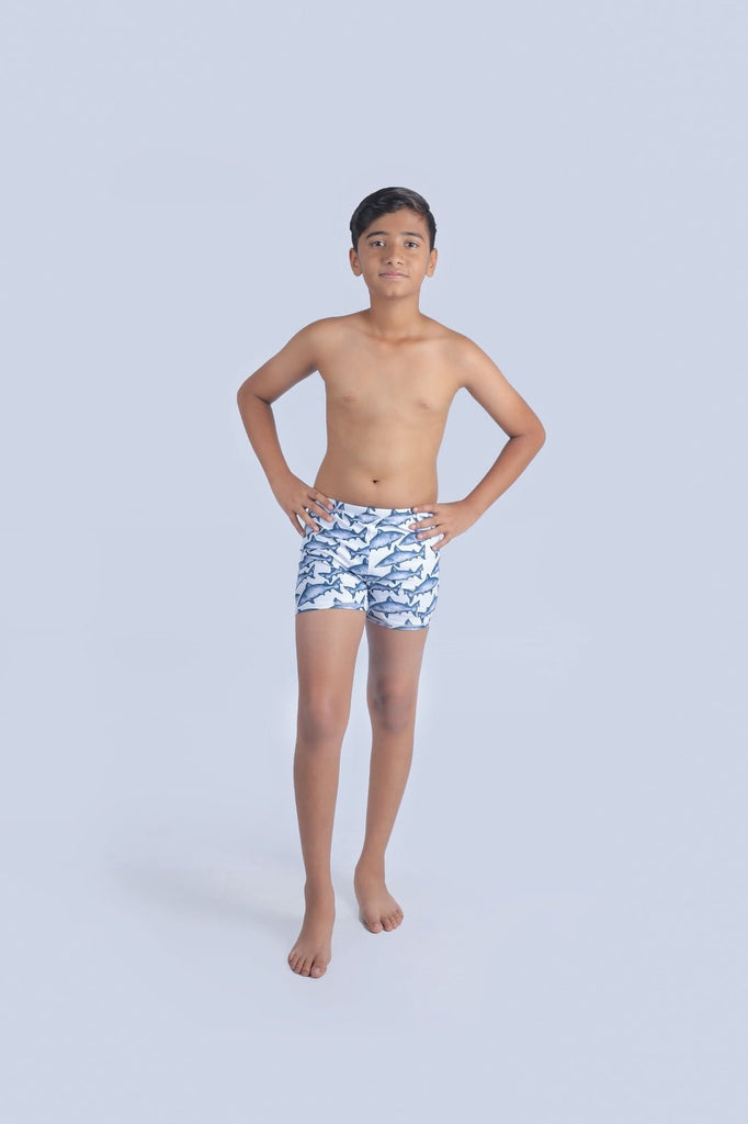 Young boy confidently wearing Yellow Bee shark-themed swim shorts