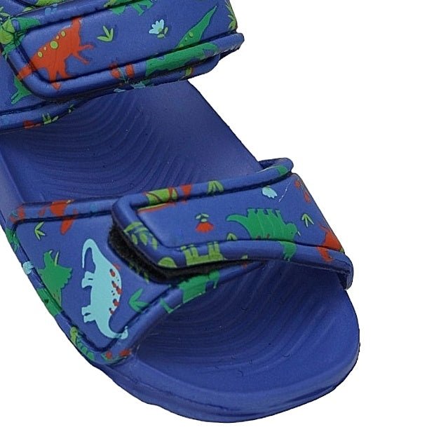 Detail shot of blue kid's sandal strap with multicolored dinosaur print design.