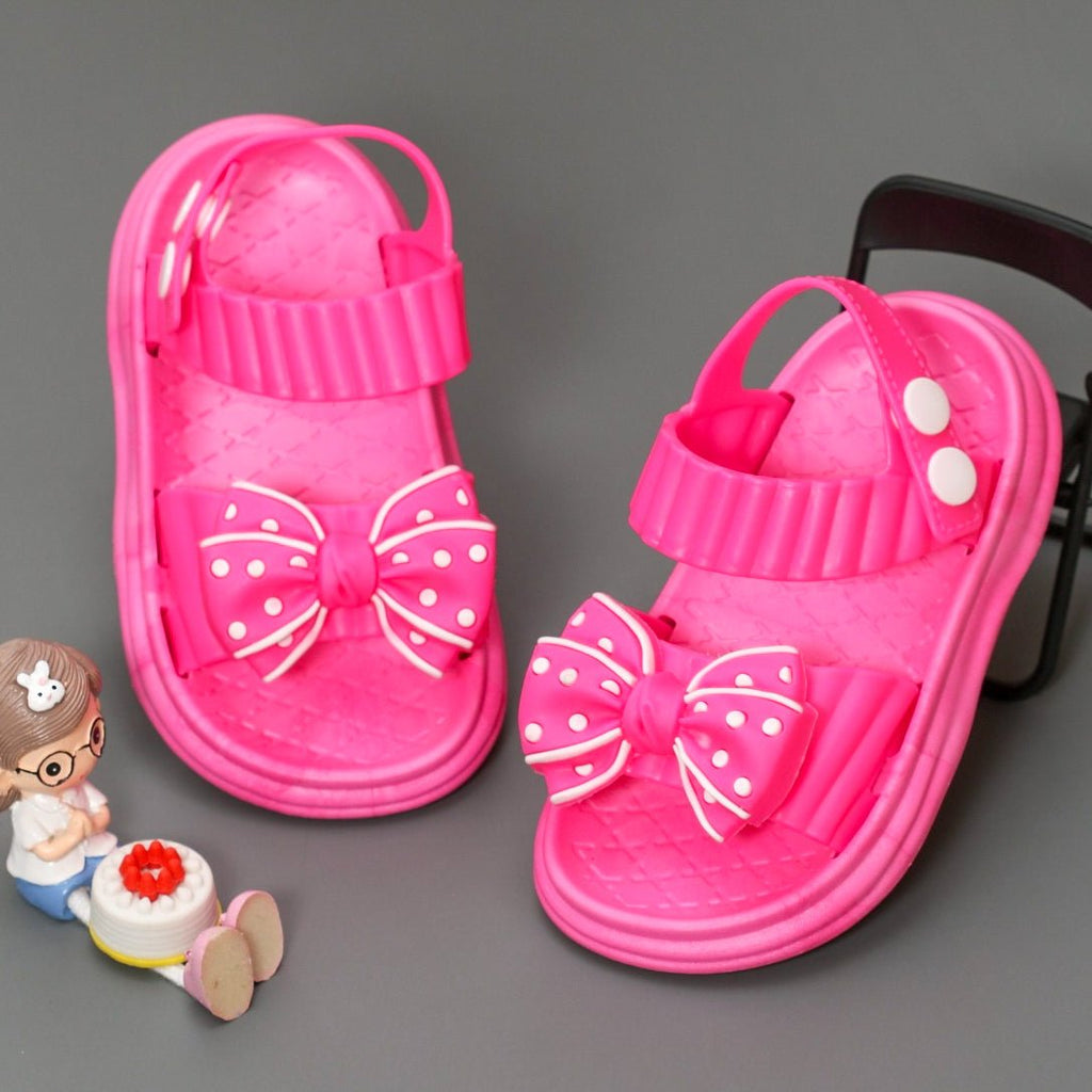 Vibrant dark pink bow detail sandals displayed with children's toys, evoking a playful and youthful vibe.