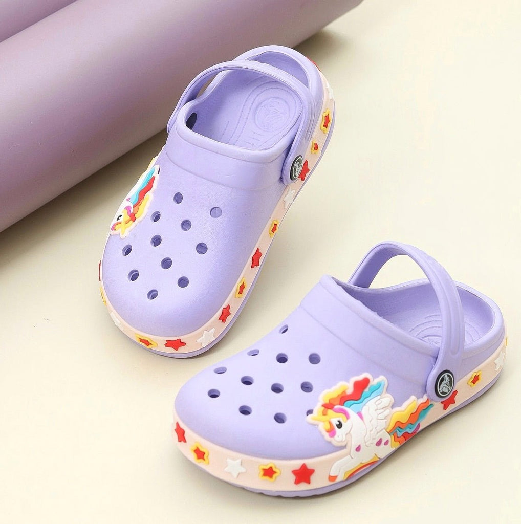 Purple children's clogs adorned with vibrant unicorn and rainbow accents on a purple background.