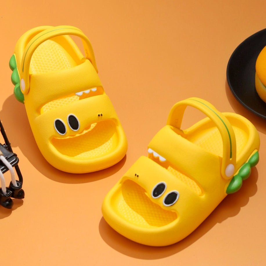 Pair of yellow dino sandals with green scales detail, showcasing a playful design for kids.