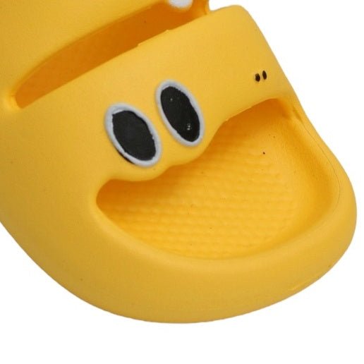 Close-up of the yellow dino sandal's face, with detailed eyes and nose for a playful effect.