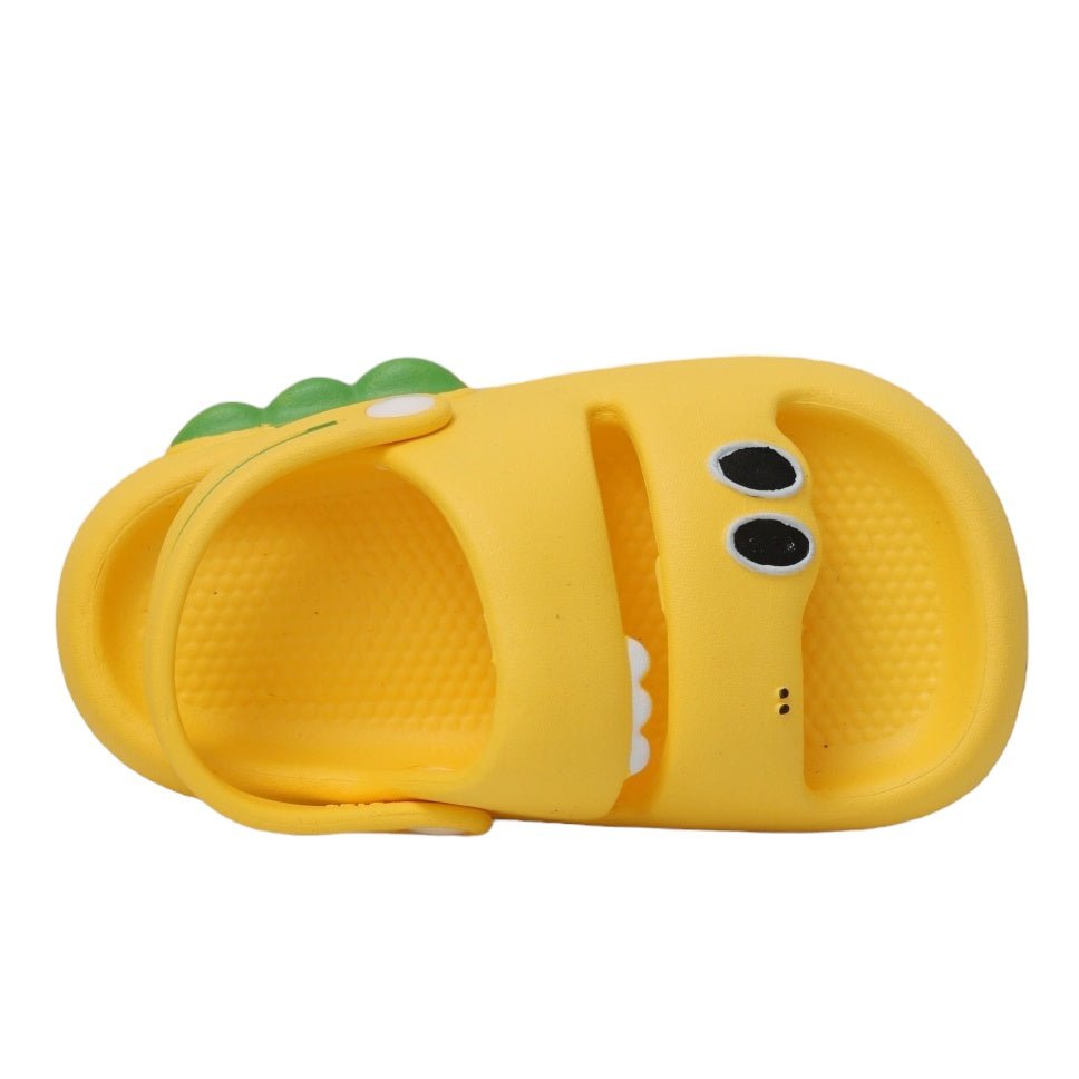  Overhead view of the playful yellow dino sandals with a focus on the green scales and secure fit.