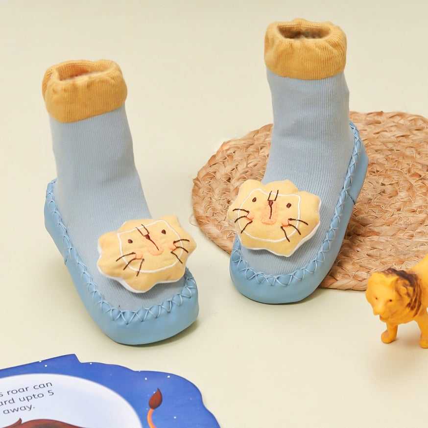 Adorable baby boy's leather socks with 3-D lion applique and anti-slip soles.