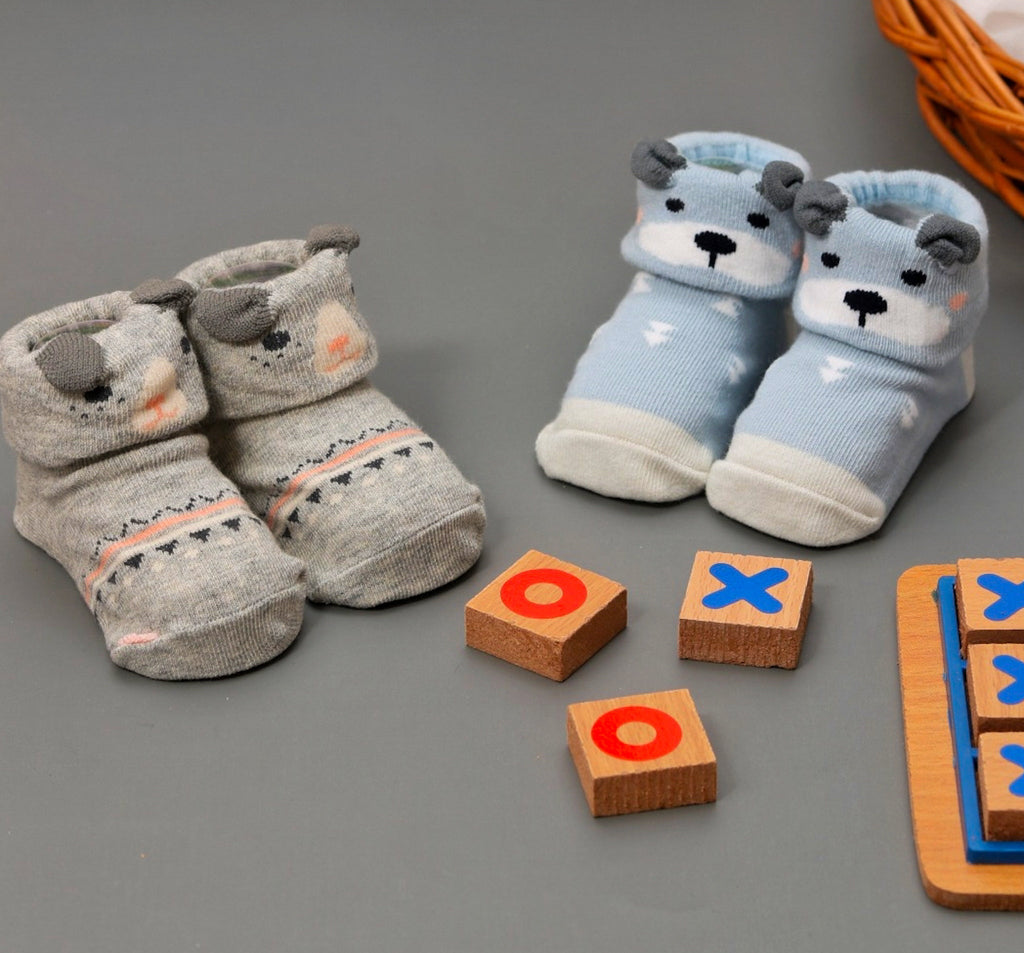 Assorted animal-themed anti-skid socks for baby boys presented with educational toys.