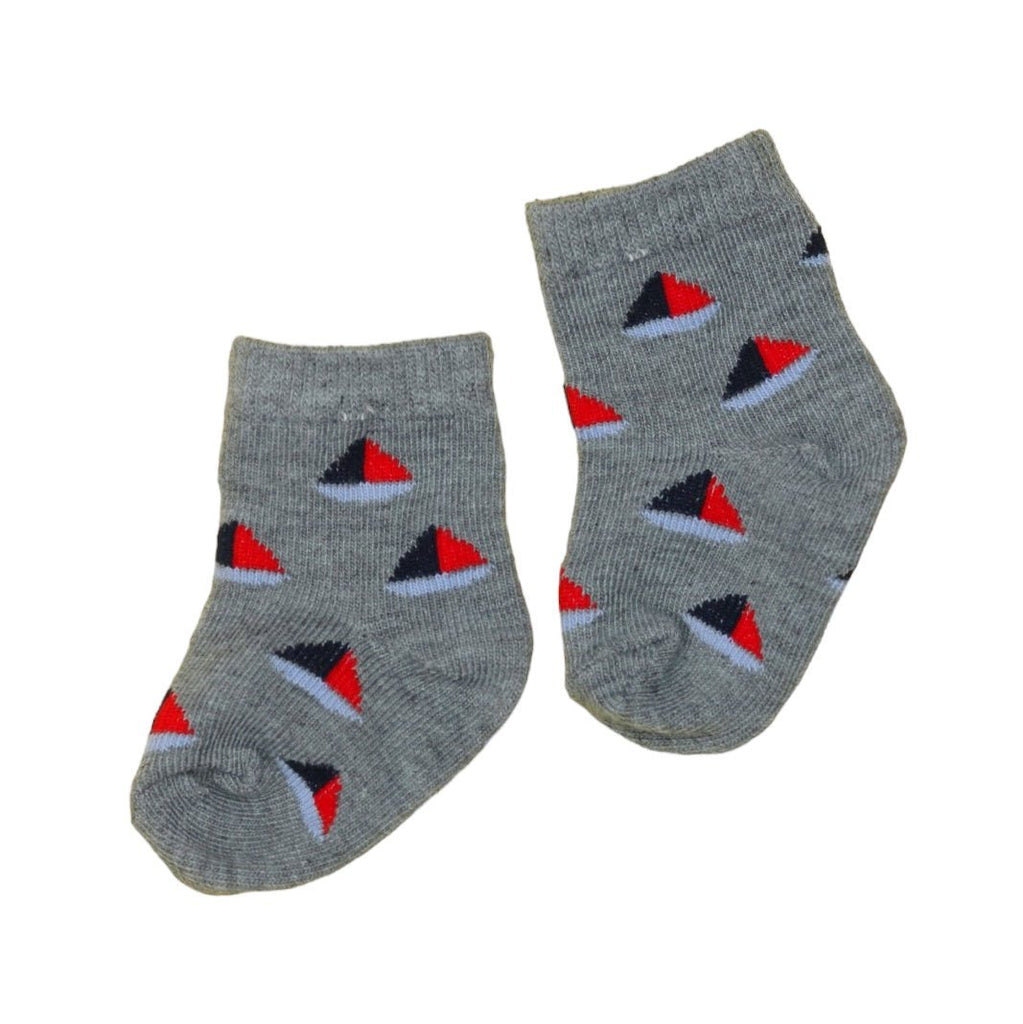 Grey baby socks adorned with red and blue sailboats on the sides