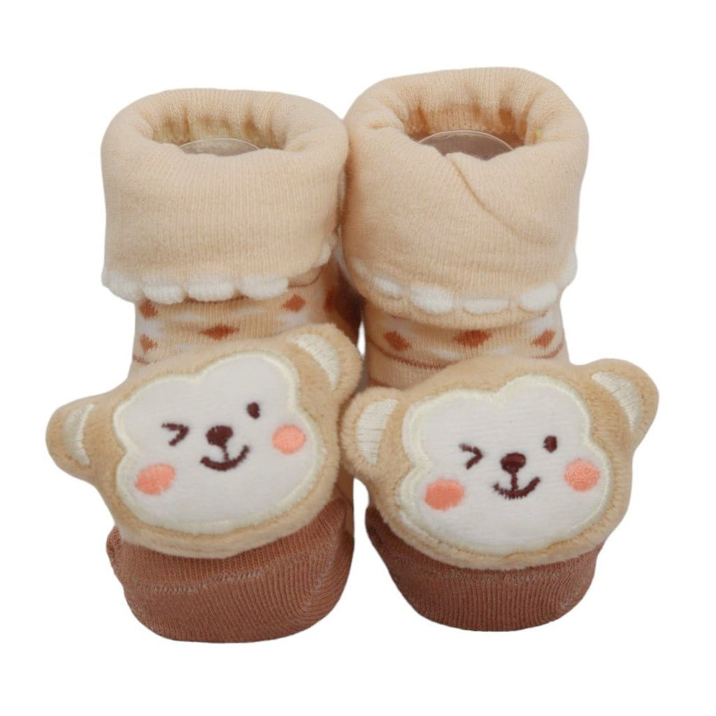 Adorable stuffed toy monkey face on cozy baby socks.