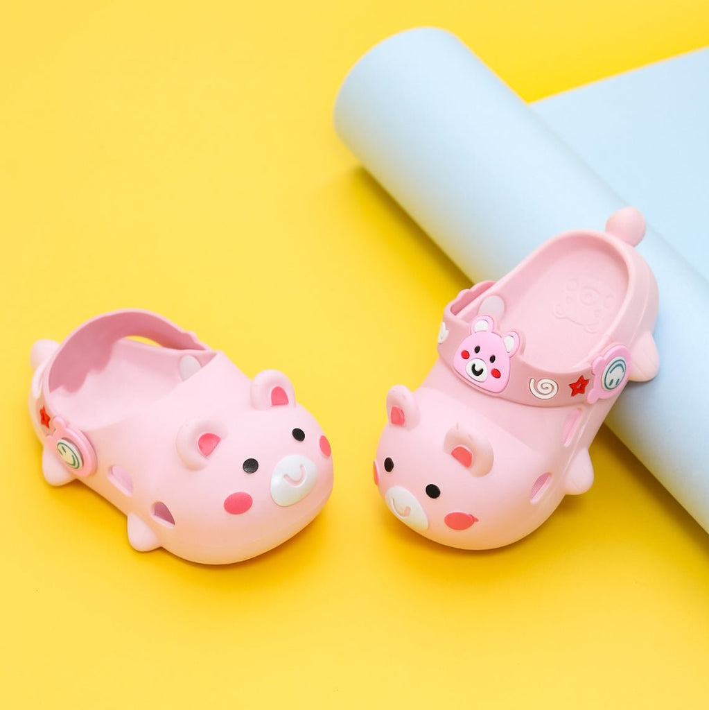 Pink bear-themed kids' clogs on a sunny yellow background, perfect for imaginative play