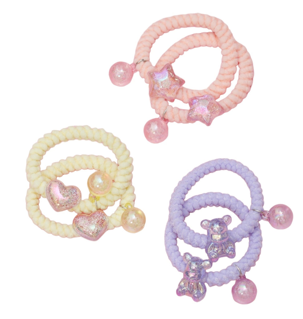 A variety of Yellow Bee's soft braided hair ties with pendants, showcasing the range of pastel colors and charm options.